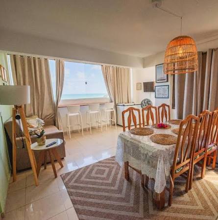 Sala de estar e jantar mobiliada com vista para o mar